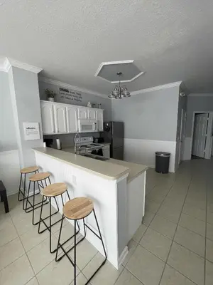 a kitchen with a counter and stools in a room at Cozy 3Br Villa With Pool Disney Nearby in Orlando