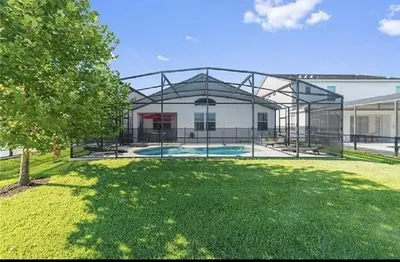 a house with a pool in the middle of a yard at Luxury Family Villa With Pool & Bbq Near Disney! in Kissimmee