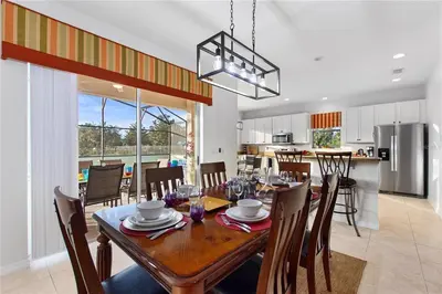 a dining room and kitchen with a table and chairs at 4Br Pool Villa, Near Disney - Gated Resort! in Kissimmee