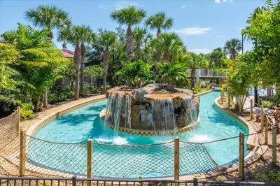a pool at a resort with a waterfall at Spacious Home in FantasyWorld in Kissimmee