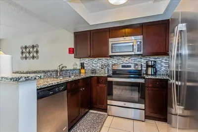 a kitchen with wooden cabinets and a stainless steel refrigerator at Spacious Home in FantasyWorld in Kissimmee