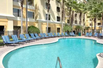 a swimming pool with blue chairs and a building at 1 BR1 Bath sleeps 6 Close to Universal Parks in Orlando