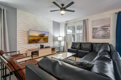 a living room with a couch and a ceiling fan at Casa9 quartos p/ família+Temas c/ piscina in Kissimmee