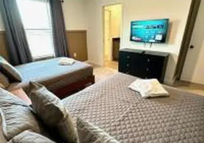 a bedroom with two beds and a flat screen tv at 3231 ED - The Hub Modern 3BR in Kissimmee