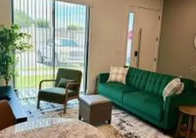 a living room with a green couch and a chair at 3231 ED - The Hub Modern 3BR in Kissimmee