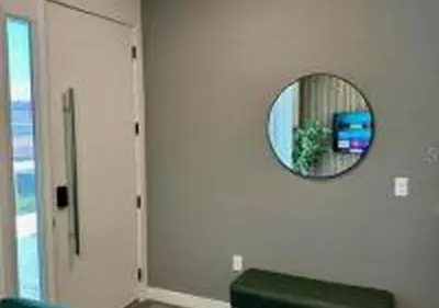 a mirror on a wall with a couch and a window at 3231 ED - The Hub Modern 3BR in Kissimmee