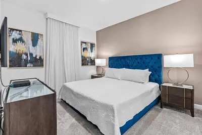 a bedroom with a large bed and a blue headboard at NEW Home 09 BedroomsPoolGame Room in Kissimmee