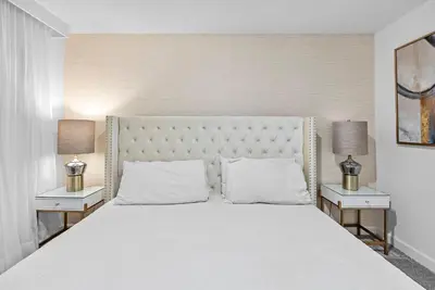 a bedroom with a large white bed with two night stands at NEW Home 09 BedroomsPoolGame Room in Kissimmee