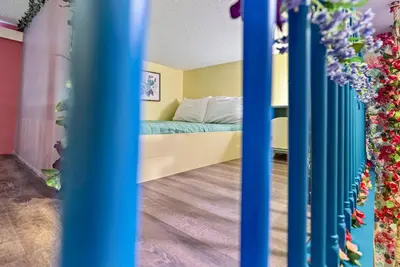 a room with a bed with blue and yellow walls at NEW Home 09 BedroomsPoolGame Room in Kissimmee