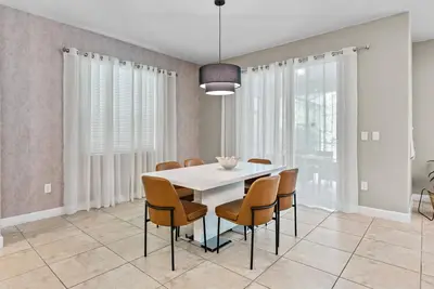 a dining room with a white table and chairs at Amazing 06 Bedrooms3 BathSleeps 14 in Kissimmee