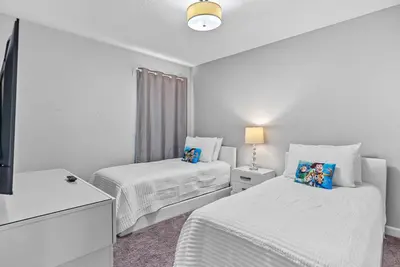 a white room with two beds and a tv at Amazing 06 Bedrooms3 BathSleeps 14 in Kissimmee
