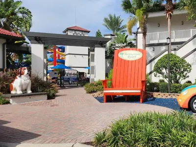 a dog sitting next to a red chair in front of a building at Family vacation Villa in Fantasy World Resort - Minutes from Disney in Kissimmee