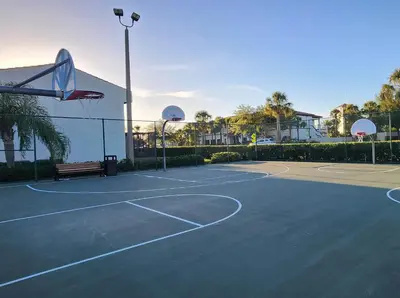 a tennis court with a bench and a basketball hoop at Family Townhouse with Waterpark - Minutes from Disney in Kissimmee
