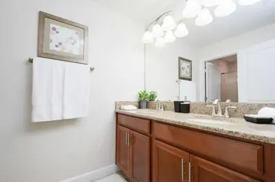 a bathroom with two sinks and a large mirror at Casa 4Q Piscina Privativa — Storey Lake Resort in Kissimmee