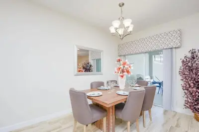 a dining room with a wooden table and chairs at Casa 4Q Piscina Privativa — Storey Lake Resort in Kissimmee