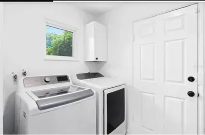 a white kitchen with a stove and a sink at Historic Retreat on Eola + Private Hot Tub + Grill in Orlando