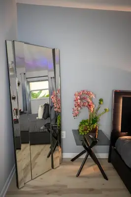 a mirror in the corner of a room with a bed at Eola Retreat Private Hot Tub with Grill in Orlando