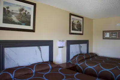 a room with two beds and pictures on the wall at Oak Ridge Inn in Kissimmee
