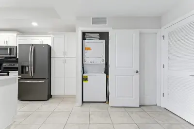 a kitchen with white cabinets and a refrigerator at Beautiful Lakeview Retreat Near Disney in Kissimmee
