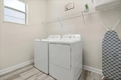 a white laundry room with a washer and dryer at 6 Bedrooms 5 Bathrooms Storey Lake 4763Kc in Kissimmee