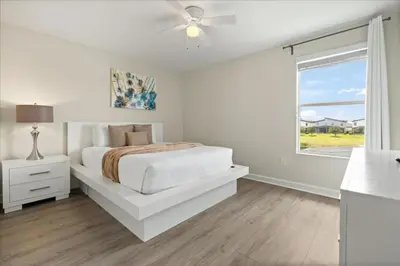 a white bedroom with a bed and a window at 6 Bedrooms 5 Bathrooms Storey Lake 4763Kc in Kissimmee