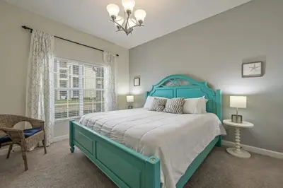 a bedroom with a blue bed and a window at Casa 4 Quartos c/ Piscina – 10 Min da Disney in Kissimmee