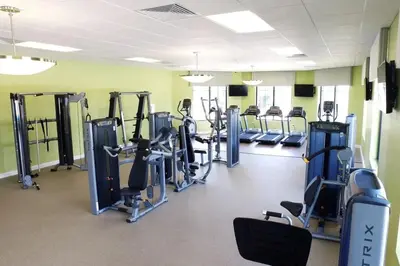 a gym with rows of tread machines in a room at Casa 4 Quartos c/ Piscina – 10 Min da Disney in Kissimmee