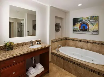 a bathroom with a tub and a sink and a mirror at Sheraton Vistana Villages 3BR Apartment with Resort Access in Orlando