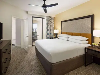 a bedroom with a large white bed with a ceiling fan at Sheraton Vistana Villages 3BR Apartment with Resort Access in Orlando