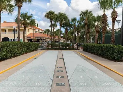 a road with palm trees and a building in the background at Sheraton Vistana Resort One Bedroom Apartment in Orlando