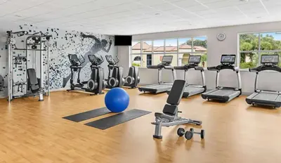 a gym with exercise equipment and a blue ball on the floor at Sheraton Vistana Resort One Bedroom Apartment in Orlando