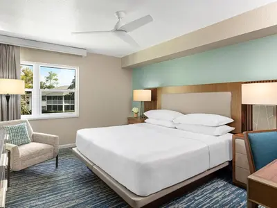 a bedroom with a large white bed and a chair at Sheraton Vistana Resort One Bedroom Apartment in Orlando