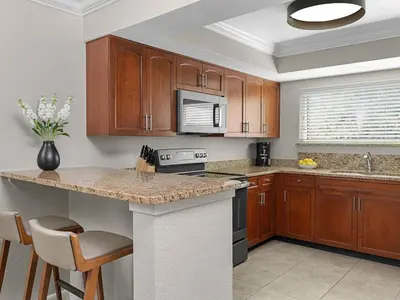 a kitchen with wooden cabinets and a counter top at Sheraton Vistana Resort Two Bedroom Apartment with Resort Access in Orlando