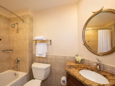 a bathroom with a sink and a toilet and a mirror at Sheraton Vistana Resort Two Bedroom Apartment with Resort Access in Orlando