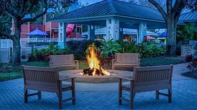 a fire pit with two benches and a table and chairs at Marriott's Harbour Lake Studio Apartment with Resort Access in Orlando