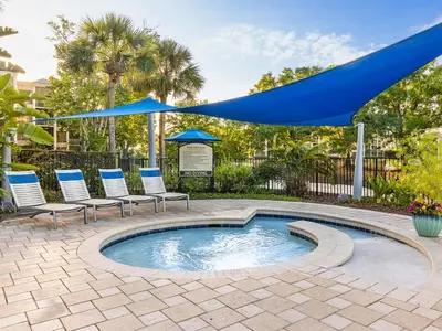 a pool with chairs and umbrellas on a patio at Marriott's Imperial Palms 3BR Apartment with Resort Access in Orlando