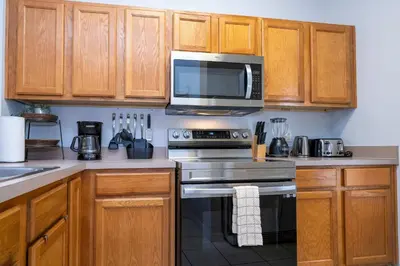 a kitchen with a stove and a microwave at Charming 3BR Resort Townhome with Private Pool near Disney in Kissimmee