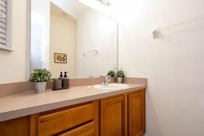 a bathroom with a sink and a mirror at Charming 3BR Resort Townhome with Private Pool near Disney in Kissimmee