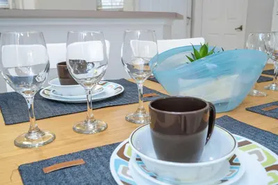 a wooden table with wine glasses and a cup on it at Charming 3BR Resort Townhome with Private Pool near Disney in Kissimmee