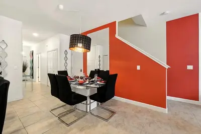 a dining room with a table and black chairs at Vibrant 5BR Family Retreat in Storey Lake in Kissimmee