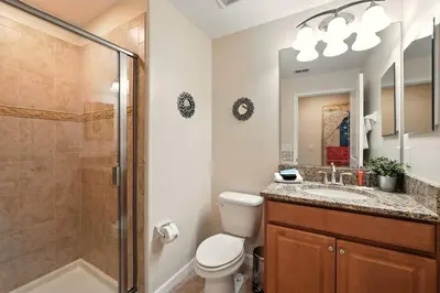 a bathroom with a shower and a toilet and a sink at Vibrant 5BR Family Retreat in Storey Lake in Kissimmee