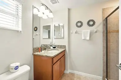 a bathroom with a sink and a mirror at Vibrant 5BR Family Retreat in Storey Lake in Kissimmee