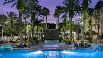 a large pool with palm trees and a screen at Marriott's Grande Vista Studio Apartment with Resort Access in Orlando