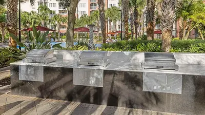 a stainless steel bench in a park with palm trees at Marriott's Grande Vista 1BR Apartment with Resort Access in Orlando