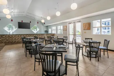 a restaurant with tables and chairs and a flat screen tv at voco Kissimmee Orlando by IHG in Orlando