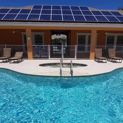 a house with a swimming pool with solar panels at Harmony in Orlando