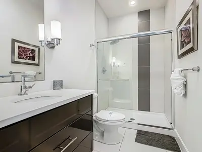 a white bathroom with a toilet and a shower at Harmony in Orlando