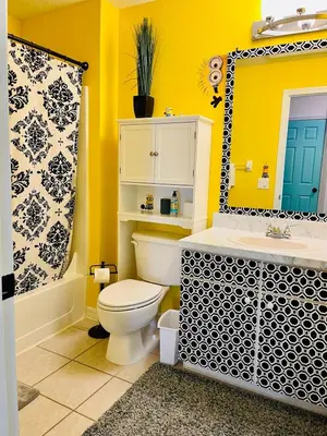 a bathroom with a toilet and a sink and a mirror at Disney Universal Theme Home! Private Pool! in Kissimmee