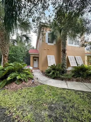 a house with palm trees in front of it at Disney Universal Theme Home! Private Pool! in Kissimmee