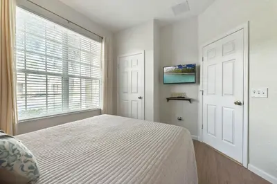 a bedroom with a bed and a large window at Disney Home in Orlando